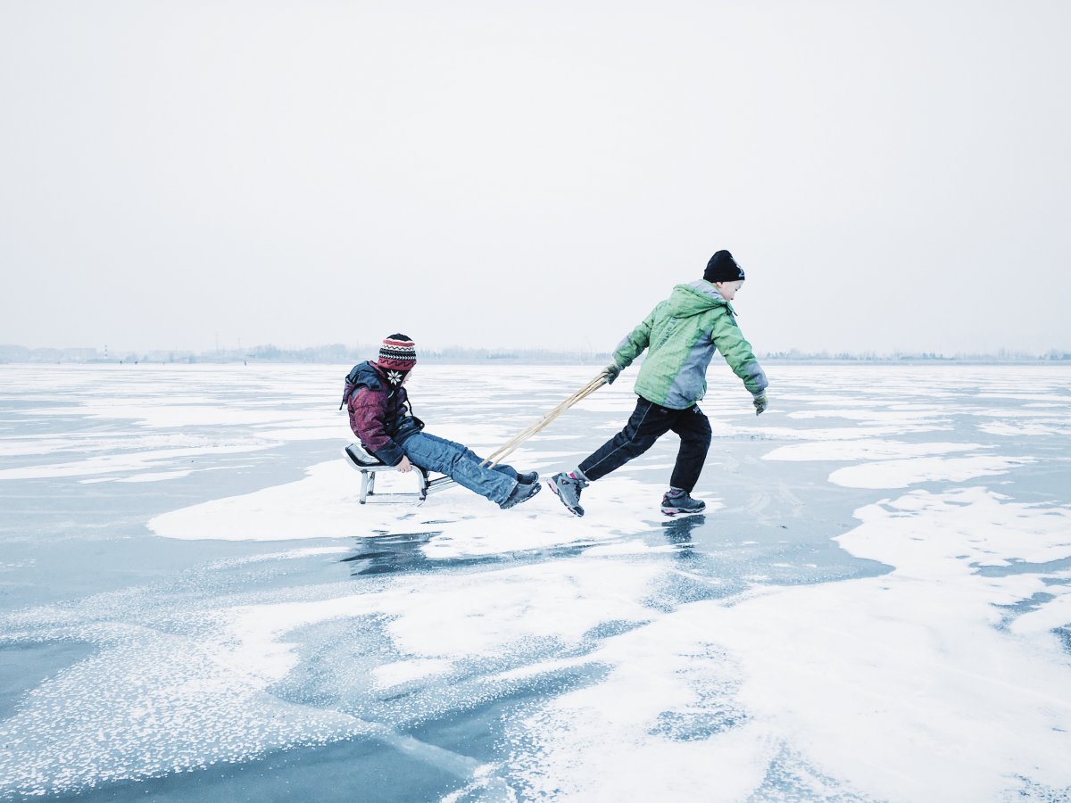 9. Chủ đề Trẻ em: ảnh chụp hai đứa trẻ chơi đùa trên dòng sông băng ngoại ô Cáp Nhĩ Tân, Trung Quốc